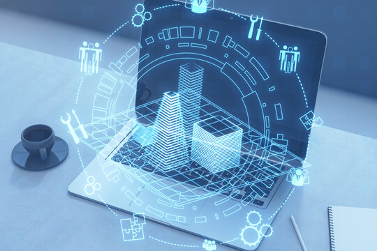 Close up of laptop on desk with coffee cup, supplies and creative digital architectural project, round wireframe sketch with icons on blurry background. Real estate, VR concept. Double exposure.