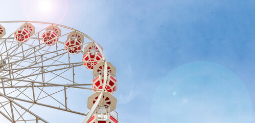 Ferris wheel and sunny sky. Space for text, banner