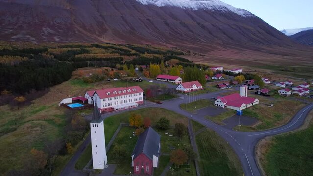 H&oacute;lar historical Icelandic village in Hjaltadalur valley. Aerial dolly out at sunset