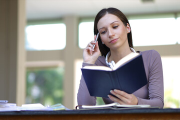 Obraz premium Female university students reading textbooks preparing for exams.