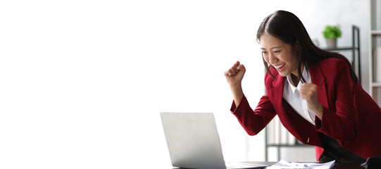 Woman looking at laptop showing excitement after successful business project.