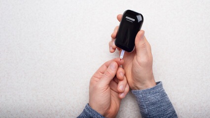 Caucasian middle aged man hands to make home testing with glucose meter flat lay view. Diabetes awareness concept