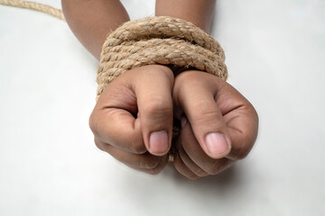 The man's hands are tied by rope