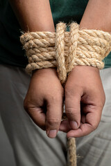 The man's hands are tied by rope