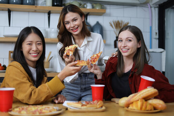 Young woman and friends having a small party in the kitchen at home.
