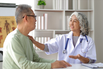 Senior health care concept. Doctor with patient in medical office. Retired man sits in a hospital examination room while discussing his health with a doctor.