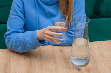 Kobieta pije czysta filtrowaną wodę ze szklanki - obrazy, fototapety, plakaty
