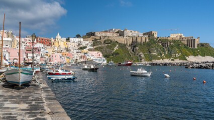 Corricella port in Procida, Italy with a variety of colorful fishing boats moored in the harbor