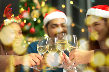 Group of diverse ethnicity young people enjoy celebrating a Christmas and New Year party together with a lot of foods and drinks. Friends celebrate Christmas and New Year festival and drink a wine.