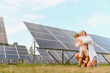 Mother with her little son by solar panels