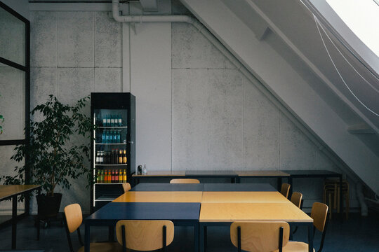 Empty dining table near refrigerator at office cafeteria