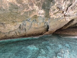 Rocks cave grotto with sea blue water. 