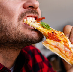 Male bearded person eating pizza close up photography.