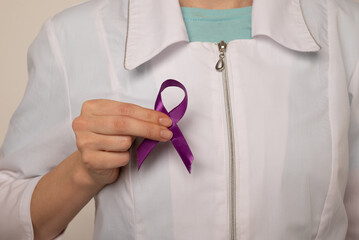 Violet purple ribbon awareness symbolic bow color in doctor's hand for Pancreatic cancer, Hodgkin's...
