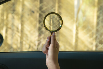 Female hand showing magnifying glass.