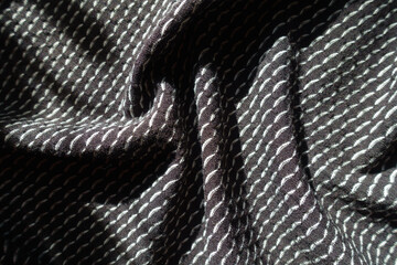 Soft folds on black and white jersey fabric with geometric pattern