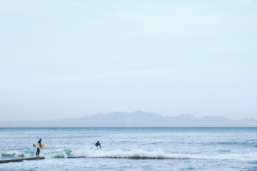 Fototapeta na wymiar Surfer enters ocean for a surf session.