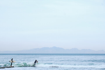 Obraz premium Surfer enters ocean for a surf session.