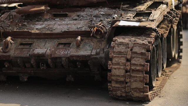 tracks and wheels of a burnt Russian tank. Side view of the tracks of a damaged Russian tank on a city street, Ukraine. The remains of a burnt out and damaged Russian army tank. war in Ukraine