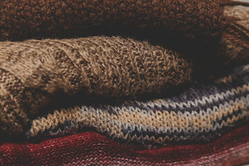 Close of image pile of knitted wool sweaters. Winter autumn cozy season concept.