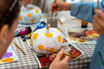 Children's drawing class. Children painting pumpkins with their parents © Alfonso Soler