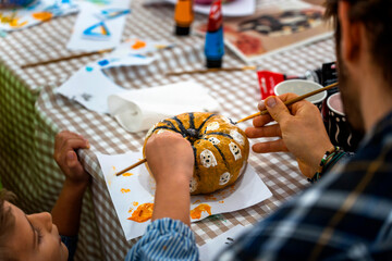 Children's drawing class. Children painting pumpkins with their parents