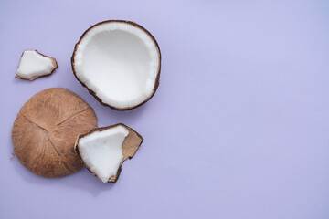 Space on the right for design, left for fresh coconut display. View from above, pastel purple background. Theme of natural cosmetics.