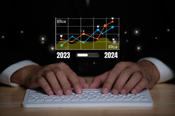 2024 business planning and strategy concept, businessman pointing virtual icon of the year 2024 target darts working on computer, phone, marketing financial analysis, investment trends next new year