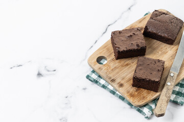 Chocolate brownie portions on marble background. Copy space