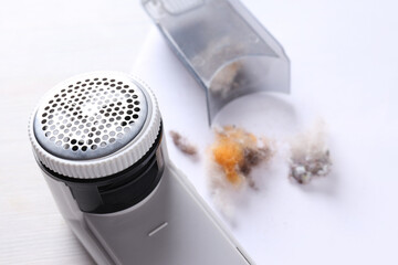 A machine for shaving fabric on clothes, on a light background.