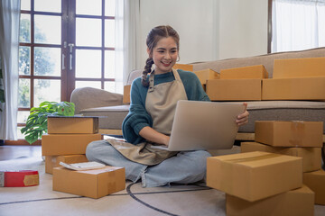 Young woman working online ecommerce shopping at her shop. Young woman seller prepare parcel box of product for deliver to customer. Online selling, ecommerce. Selling products online