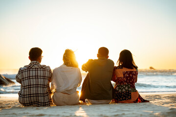 Four People Sitting on the Beach at Sunrise - obrazy, fototapety, plakaty
