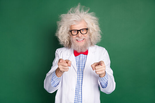 Photo of happy cheerful good mood funky mad scientist with messy hair point finger you isolated on green color background