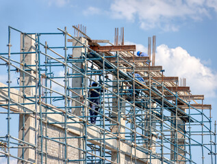 Fototapeta premium african american workers climbed on the scaffolding at a construction site of a commercial building