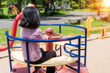 Cheerful child girl playing on playground in the park. Healthy summer activity for children.