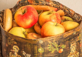 Apples and bagels in a painted birch bark basket