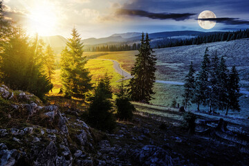 autumn mountain landscape with sun and moon at twilight. asphalt road winding through mountains passes the meadow near evergreen coniferous shaded forest. day and night time change concept