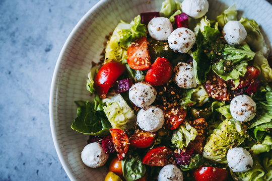 Salade verte avec des tomates fraiches des billes de fromage et graines - Assiette app&eacute;tissante saine