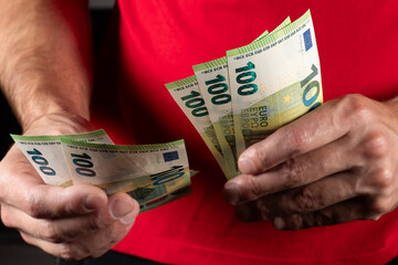 Men hold hundred euro bill in his hands, pay with euros, poverty in europe, no cashless paying - obrazy, fototapety, plakaty