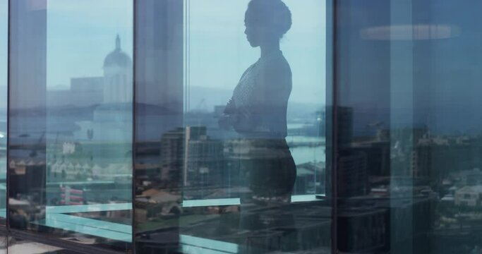 Business, woman and window with arms crossed, thinking and ideas in corporate office for review or meeting. Professional, employee and shadow or reflection with leadership, thoughtful and daydreaming
