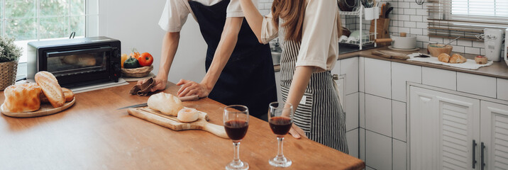 Hands knead the dough on a board for baking bread in the kitchen