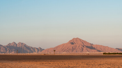 Fototapeta na wymiar Panoramic view on sand, mountains hills in South Sinai desert, Egypt. Orange sand and haze.
