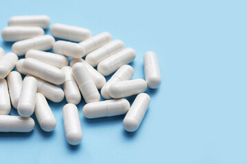 Medicine capsules on blue background.
