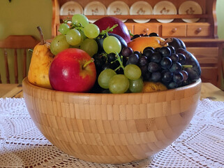 bamboo bowl with ripe fruits at the table