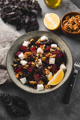 Salad of kale, roasted beets, walnuts and feta cheese on the table vertical photo