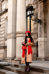 Fototapeta na wymiar Glamorous woman in a short dress in the city. A woman goes shopping. Autumn
