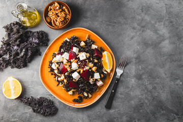 Salad of kale, roasted beets, walnuts and feta cheese on the grey background top view copy space for text