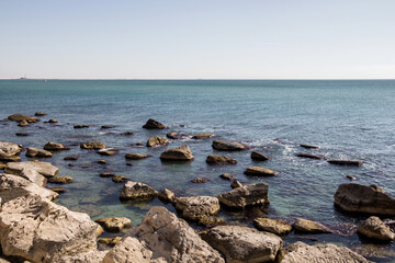 Fototapeta na wymiar Rocky shore of the Caspian Sea. Large stones on the seashore. A heavenly place. Embankment of the Caspian Sea in the city of Aktau.