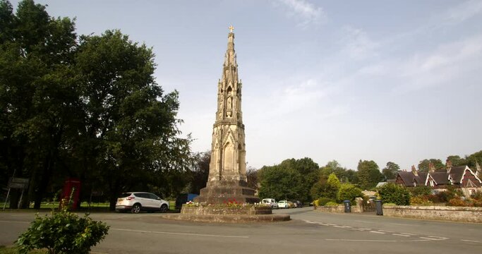 wide shot of a stone monument, park cross. In the village of Ilam