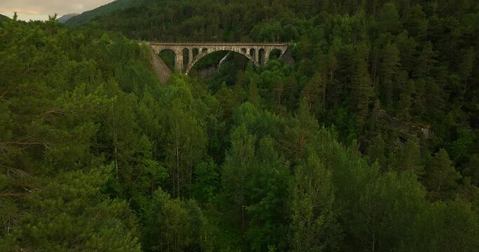 Aerial tilt-up of historic Kylling bru, stone railway bridge in Verma, Norway